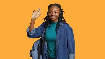Enthusiastic african american student raising hand up to answer question, excited to tell teacher explanation to question in class, isolated over studio background, camera A photo