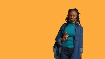 Anxious student at school thinking of raising arm to answer question but unsure of herself, studio background. Teenager lacking confidence needed to volunteer saying explanation to question, camera B photo
