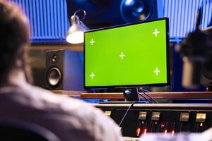 Singer and expert mixing and processing music for a new album in control room at professional recording studio, working on songs. Diverse team of artists producing a new tune. photo