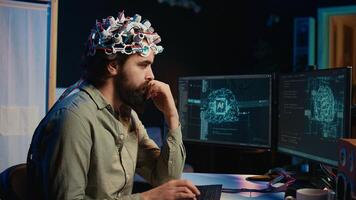 IT expert using EEG headset and machine learning to upload brain into computer, gaining immortality. Computer scientist develops AI experiment, inserting his persona into cyberspace, camera B photo
