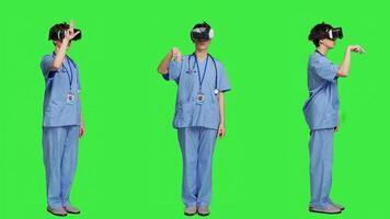 Health specialist using vr headset to examine patient diagnosis, stands against greenscreen backdrop. Nurse works with artificial intelligence virtual reality glasses, three dimensional. Camera A. photo