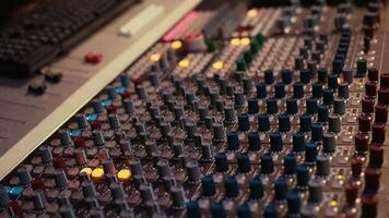 Sound designer manipulating sound effects to enhance tunes on audio recordings, processing and mixing tracks to create a new song. Professional expert works in control room at studio. Camera B. photo