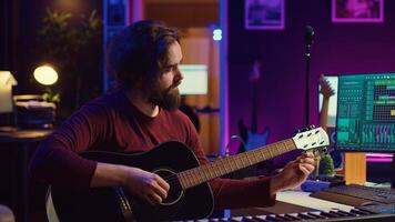 Musician trying to tune the sound of his guitar in home studio, adjusting knobs before playing tunes and recording on daw software. Advanced mixing and mastering techniques. Camera A. photo