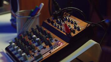 Electronic instruments used for mixing and recording tunes in empty home studio, soundboard controls and mastering console used to create songs. Creative space with amplifier and equalizer. Camera A. photo