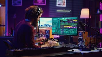 Music engineer operates recording equipment in home studio, working with mixing consoles and digital audio workstations to create sound effects on soundtracks. Production techniques. Camera A. photo