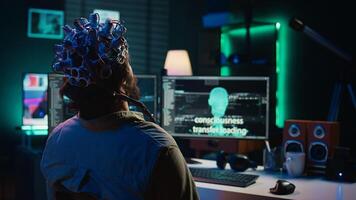 Engineer with EEG headset on programming brain transfer into computer virtual world, merging with artificial intelligence. Transhumanist using neuroscience to gain digital soul, camera B photo