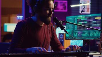 Songwriter recording a new song with microphone and midi controller, playing piano keys in home studio. Talented artist producing music with modern electronic keyboard and tools. Camera A. photo