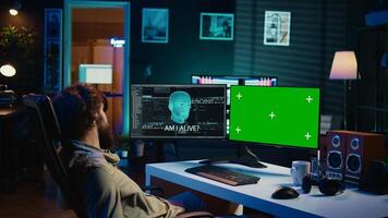 Programmer being asked existential questions by awaken AI on mockup PC gaining consciousness. Man communicating with artificial intelligence through green screen computer, camera B photo
