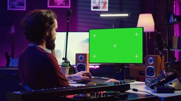 Sound engineer beginner learning acoustical engineering and mastering for music industry post production. Artist watches tutorial on greenscreen pc to use mixing console and equalizer. Camera A. photo