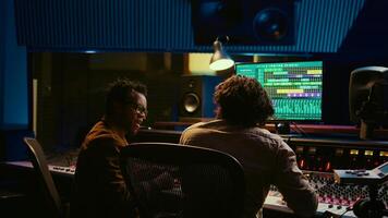 Pleased artist and tracking engineer doing high five gesture after creating a song together, happy with the final result. Team of singer and producer celebrating successful track collab. Camera B. photo