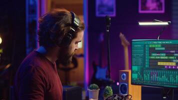 Mastering engineer registering piano keys recordings to edit in daw software on computer, operating his mixing equipment. Artist works on editing and manipulating recorded sounds and tunes. Camera A. photo