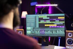 Sound engineer working with audio recordings on daw software interface, editing and adjusting volume levels for new music. Producer adding sound effects on soundtracks, signal processing. photo