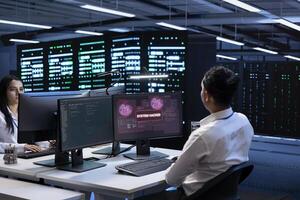 Teamworking developers in server room trying to protect hardware from cybercriminal attack. Data center cybersecurity division colleagues fighting malware during security breach photo