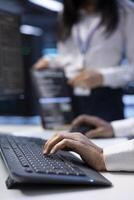 Supervisor checking event logs on computer to find out of order data center electronics root cause. Electrician using PC to review blade servers operating system configuration settings, close up photo