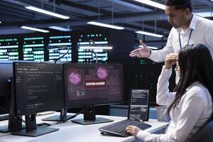 Computer scientist in server hub asking coworker for help, trying to protect equipment from hacker. IT specialist in data center facility requesting assistance to fix security breach alert photo