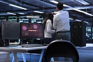 Team of programmers in server hub trying to protect hardware from hacker attack stealing sensitive information. Data center cybersecurity division coworkers fighting virus during security breach photo