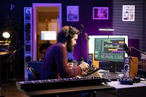 Audio producer twisting pre amp knobs on console to edit music, recording tunes with daw software on pc in home studio. Artist composing soundtracks with stereo gear and amplifier. photo