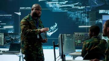 Military officer leads cybersecurity efforts in a high tech control center, ensuring data protection and managing surveillance systems, Coordinating national security operations. Camera A. photo
