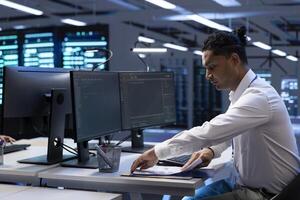 Engineer maintaining accurate documentation of data center infrastructure, configurations, and procedures. Server room employee establishing performance benchmarks and conduct analysis photo