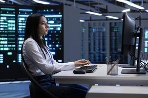 Engineer in data center checking equipment performance on PC after installing and upgrading hardware components such as servers, storage devices, and networking equipment photo