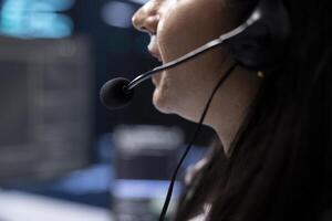 Data center support specialist supporting engineering team doing hardware maintenance, talking in headset microphone. Close up of employee in server hub coordinating technicians using mic photo