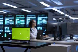 Focus on green screen laptop in data center facility managing rackmounts energy consumption. Mockup notebook used for automation and monitoring processes in server room, close up photo