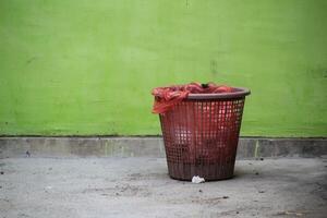 Red Trash Can with Green background and empty space photo