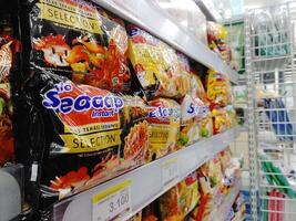 Lombok, Indonesia, February 12 2024 - Close-up view of instant noodle retail products on display at an Indonesian minimarket photo