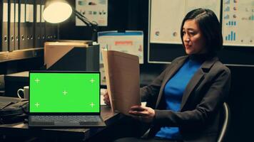 Private detective analyzing case files and uses greenscreen on pc, working on new investigation in archive room. Police officer reads archived folders, isolated chromakey template. Camera A. photo