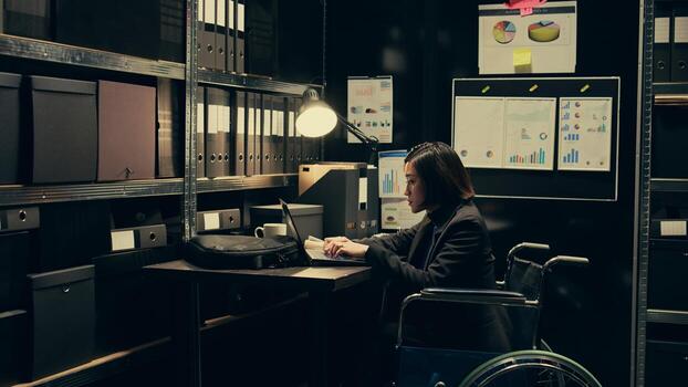 Wheelchair user and inspector analyzing criminal records in police archive room, cross reference data from cases to identify similarities. Team of agents compile notes on crime trends. Camera B. photo