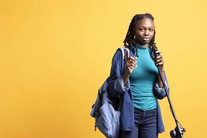 Portrait of african american motivational speaker talking in microphone, addressing audience, isolated over studio background. Expressive BIPOC lecturer using mic, inspiring motivation photo