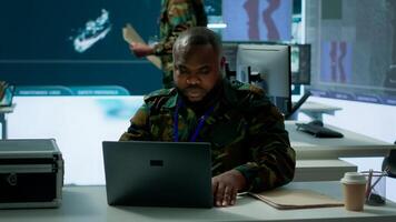 Army intelligence expert utilizes modern computer systems and satellite radar imagery to enhance national security, strategic initiatives and ensure defense in mission control center. Camera A. photo
