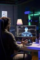 Admin confused by AI gaining consciousness, using humanoid form to interact with creator. Computer technician astonished by artificial intelligence becoming sentient and appearing on monitor photo