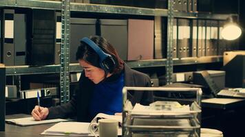 Agent extracting cryptic references found in classified records that may require further deciphering or analysis, archive room work. Law officer trying to break codes to find details. Camera A. photo