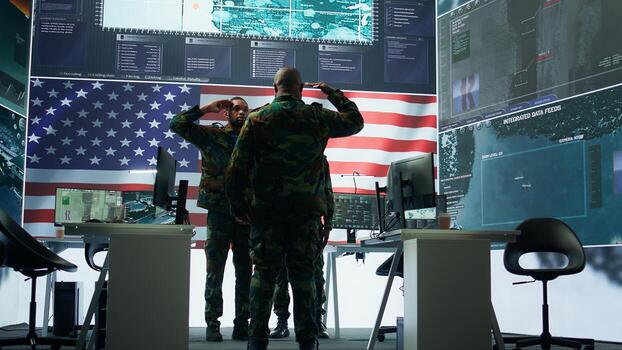 US soldiers in a high tech command center protecting classified information, ensuring cybersecurity and defending against cyber attacks. Army base of operations with trained officers. Camera B. photo