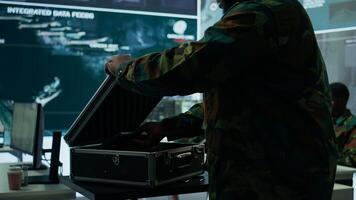 Government intelligence expert works on laptop in a command center to manage surveillance operations, collecting real time data for security measures. Protecting national interests for efficiency. Camera B. photo