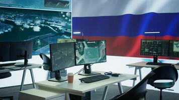 Empty russian army command center with a big screen showing the national flag, working on spreading fake news and propaganda to inflict fear and misinformation. Terrorist ideology. Camera B. photo