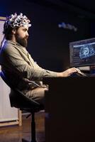 Programmer using EEG headset translating thoughts into PC commands using brainwave signals. Man controlling computer functions using his mind, helped by biosensor technology research photo