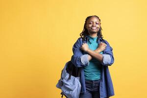 Assertive african american woman shows letter X with arms crossed, staying in warrior stance, showing fierceness. Firm BIPOC person using negative body language to signal rejection, studio background photo