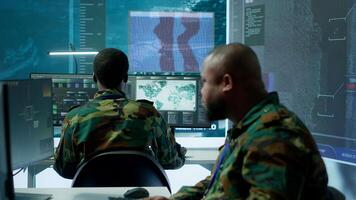 US soldiers in a high tech command center protecting classified information, ensuring cybersecurity and defending against cyber attacks. Army base of operations with trained officers. Camera B. photo