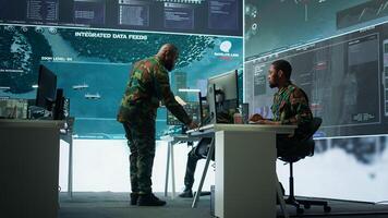 Skilled team of military specialists operate advanced technology and a big screen in a control center, managing surveillance footage via cctv radar system. Safety mission department. Camera B. photo