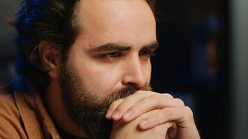 Programmer in home office concentrating on finding bugs while doing coding on computer, extreme close up shot. IT admin frowning while looking at screen, confused by errors in lines of code, camera A photo