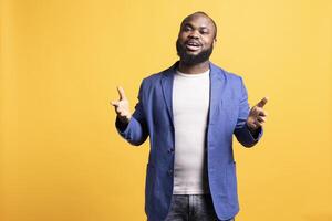 Portrait of african american lecturer holding monologue and gesturing with hands, isolated over studio background. Expressive BIPOC speaker moving arms while talking during presentation photo