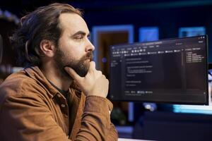 Introspective developer coming up with solutions to futureproof company network from downtimes and unexpected system failures. IT professional debating ways to increase data security photo