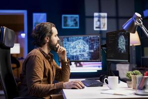 Teleworking programmer using computer for artificial intelligence computing simulating human brain through self learning algorithms. Remote worker working with AI deep neural networks on desktop PC photo