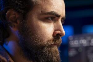Programmer with frown on face trying to fix vulnerabilities in software enabling attackers to compromise systems. Cybersecurity expert focused on patching security exposures, close up photo