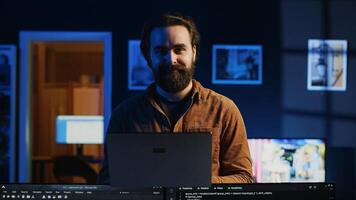 Portrait of smiling developer writing complex binary code scripts on laptop terminal. Cheerful remote IT employee standing in home office, using programming to safeguard consumer data, camera A photo