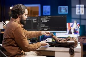 Programmer packing laptop at end of work shift after securing company servers from virus attacks. Man putting notebook in backpack, leaving office after building firewalls protecting data photo