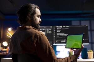 Programmer using green screen tablet to fix vulnerabilities in software. Man taking care of security exposures in operating system, writing code on mockup portable device photo