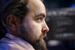 Cybersecurity expert in apartment using computer to look for security liabilities. Programmer focused on installing safeguard code on PC to prevent firewall breaches, close up shot photo